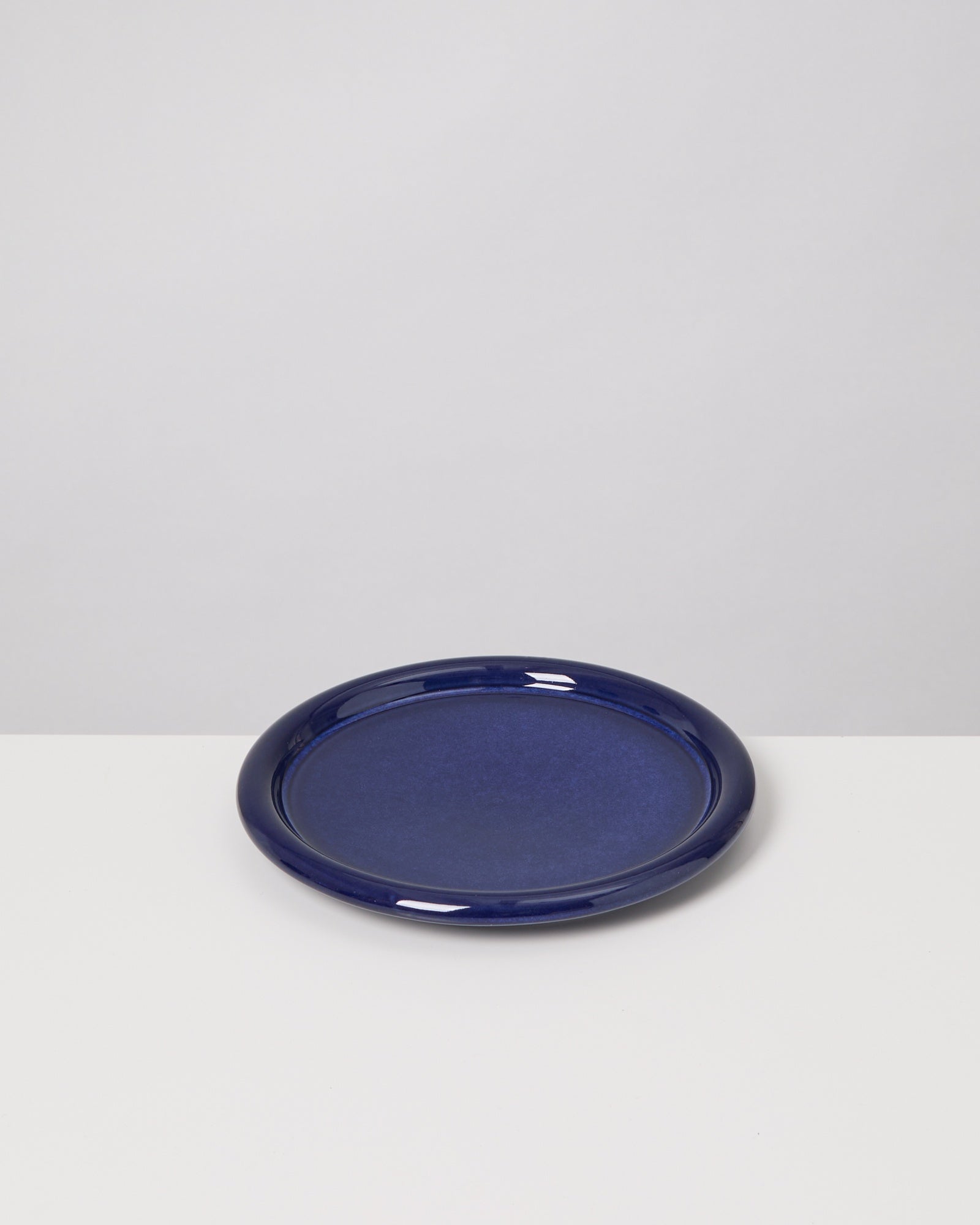 Tiefer blauer Teller auf weißem Untergrund.