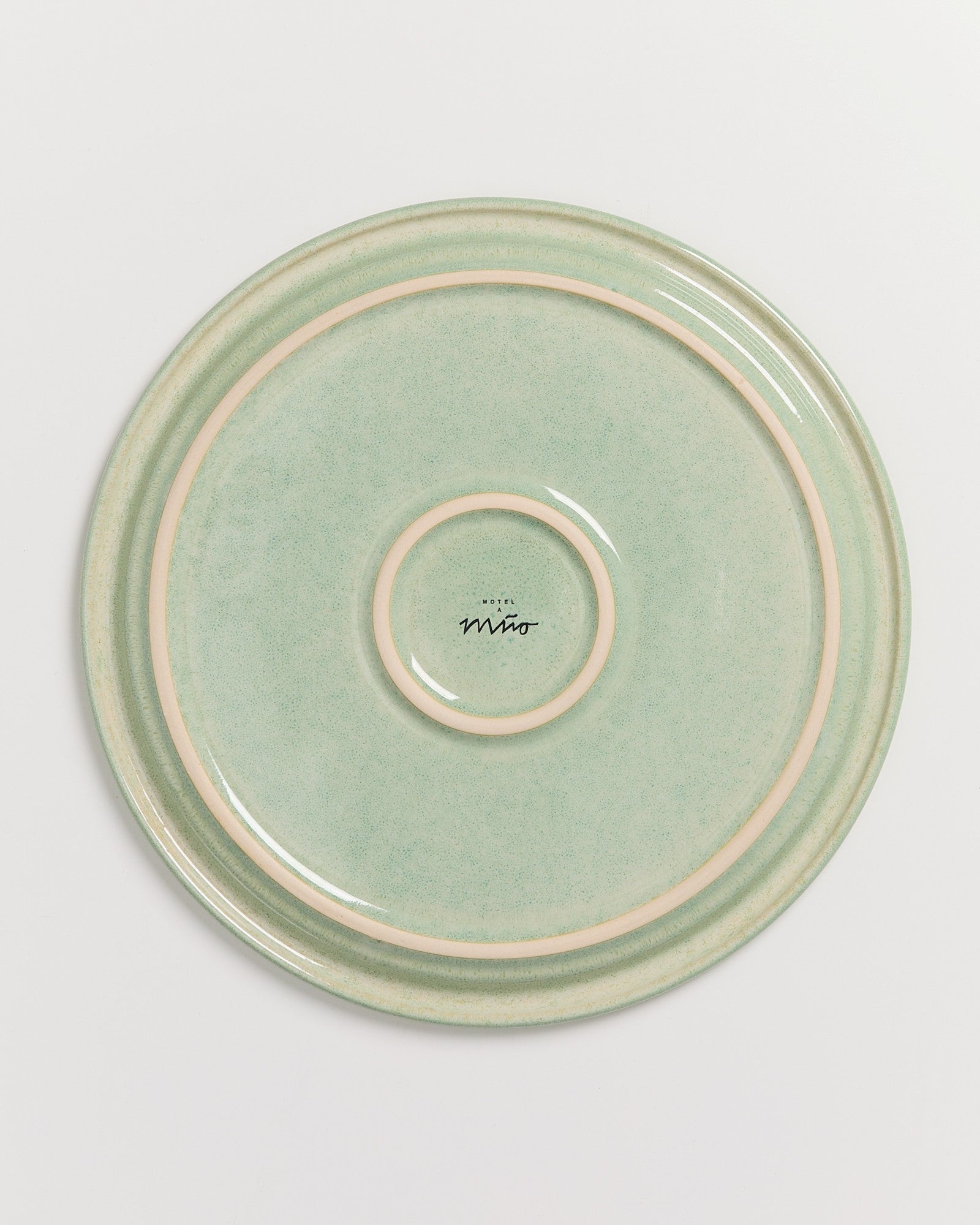 Grüner Teller mit hellen Kreisen und dem Schriftzug "Hotel Miro" in der Mitte.