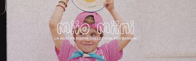 Ein Kind in rosa Kleidung hält einen Teller mit einem Löwenmotiv hoch, Text: "Miio Miini, La nostra nuova collezione per bambini".