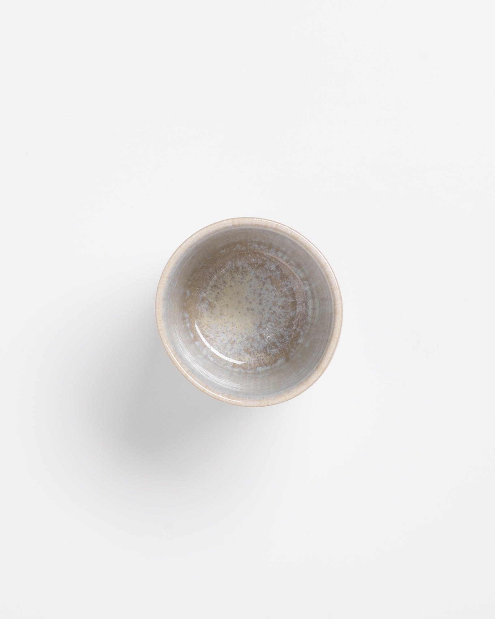 Kleine, graue Keramikschale mit gesprenkelter Glasur auf weißem Hintergrund.